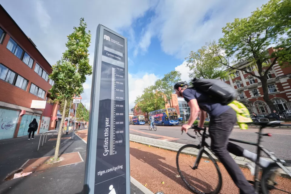 Black bike counter with cyclists passing by on Manchester, UK bike path